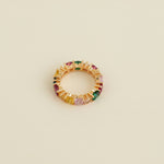 Jewelry ring with multicolored stones on a light gray background