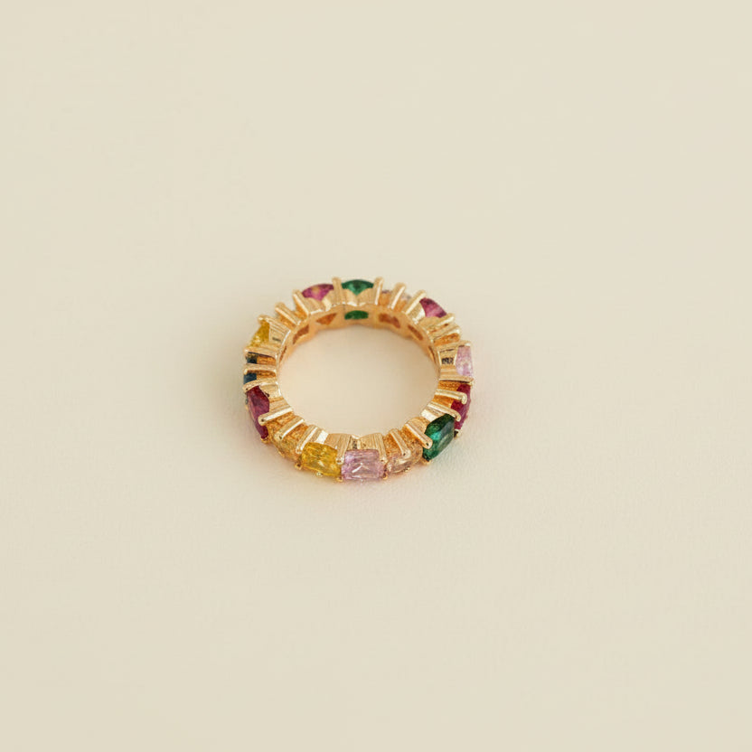 Jewelry ring with multicolored stones on a light gray background