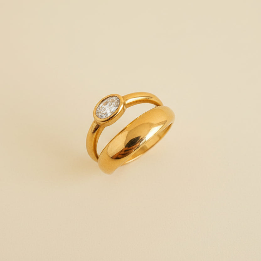 Gold ring with a diamond on a beige cylindrical object against a light background