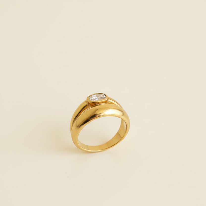 Gold ring with a diamond on a light gray surface