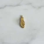 Gold shoe charm on a marble background