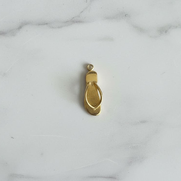 Gold shoe charm on a marble background