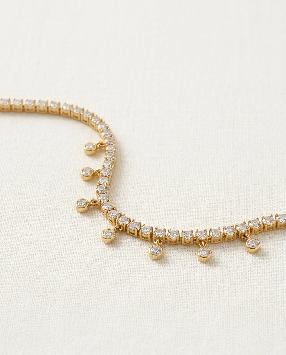 Gold bracelet with clear stones on a light beige background