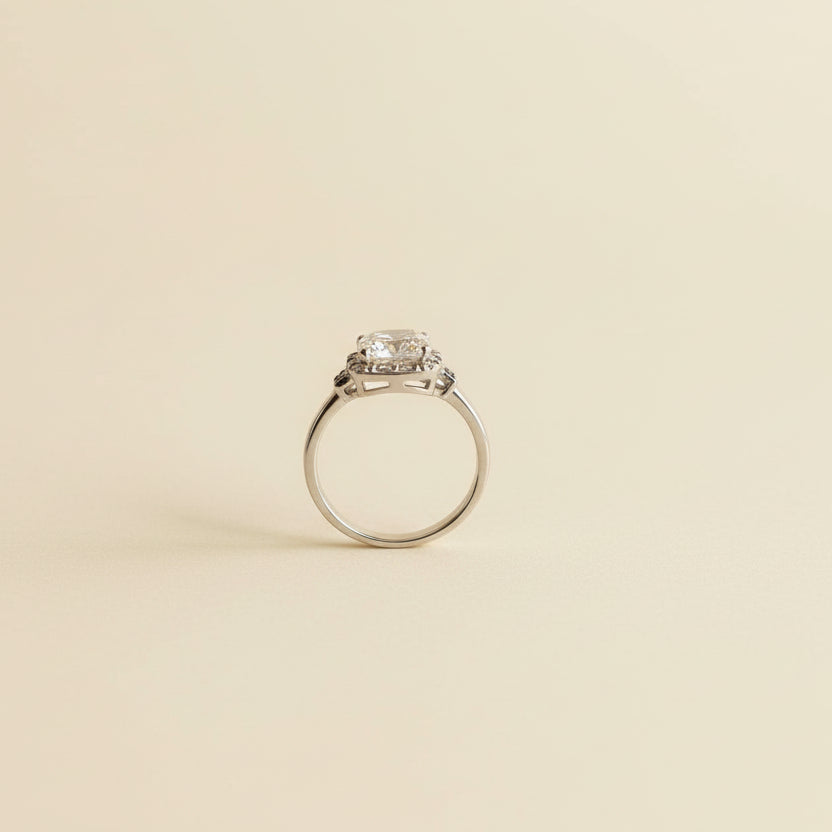 Silver ring with a diamond on a light gray marble surface