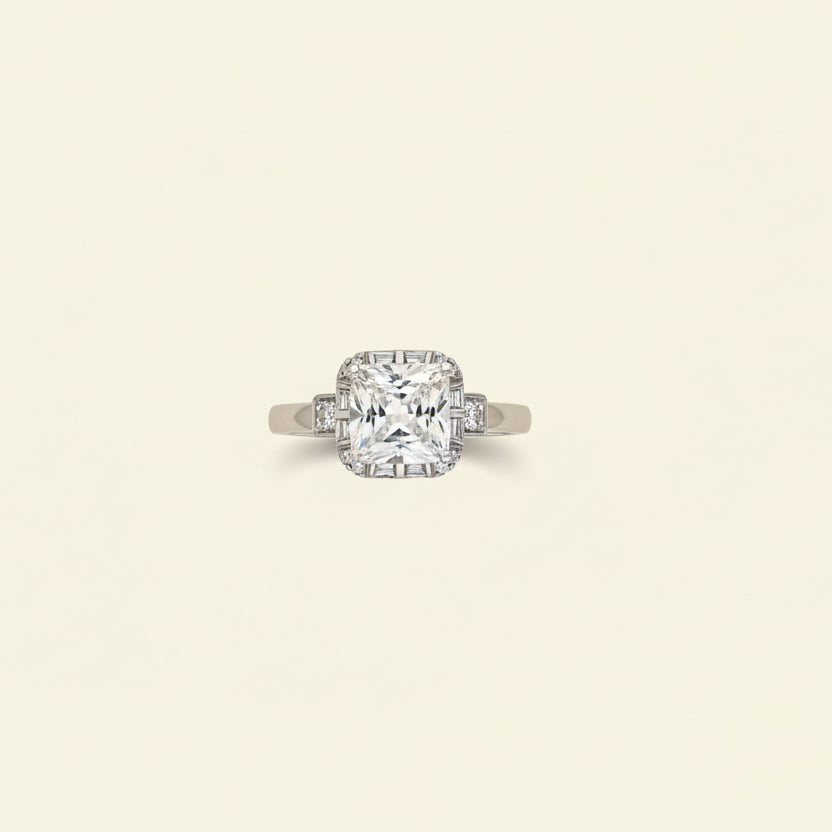 Diamond ring on a light beige cushion against a light gray background