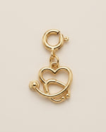 Gold stethoscope-charm on a beige background
