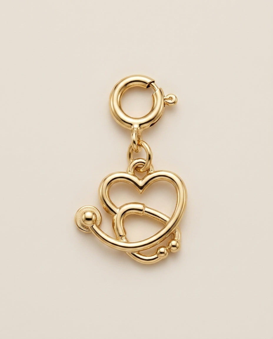 Gold stethoscope-charm on a beige background