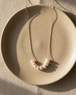 Pearl necklace on a beige plate with a neutral background