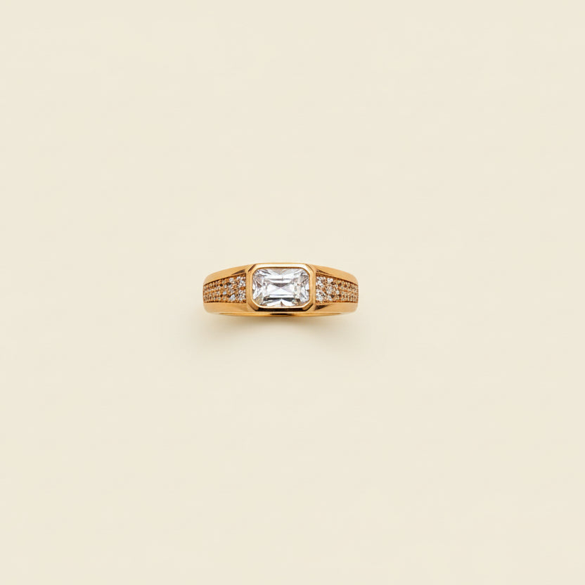 Rose Gold ring with a diamond on a beige cushion against a light gray background