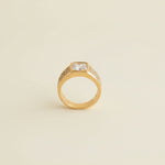 Gold ring with a diamond on a light gray surface