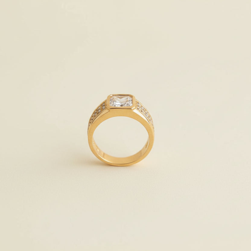 Gold ring with a diamond on a light gray surface
