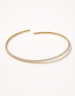 Gold headband with embedded crystals on a white background