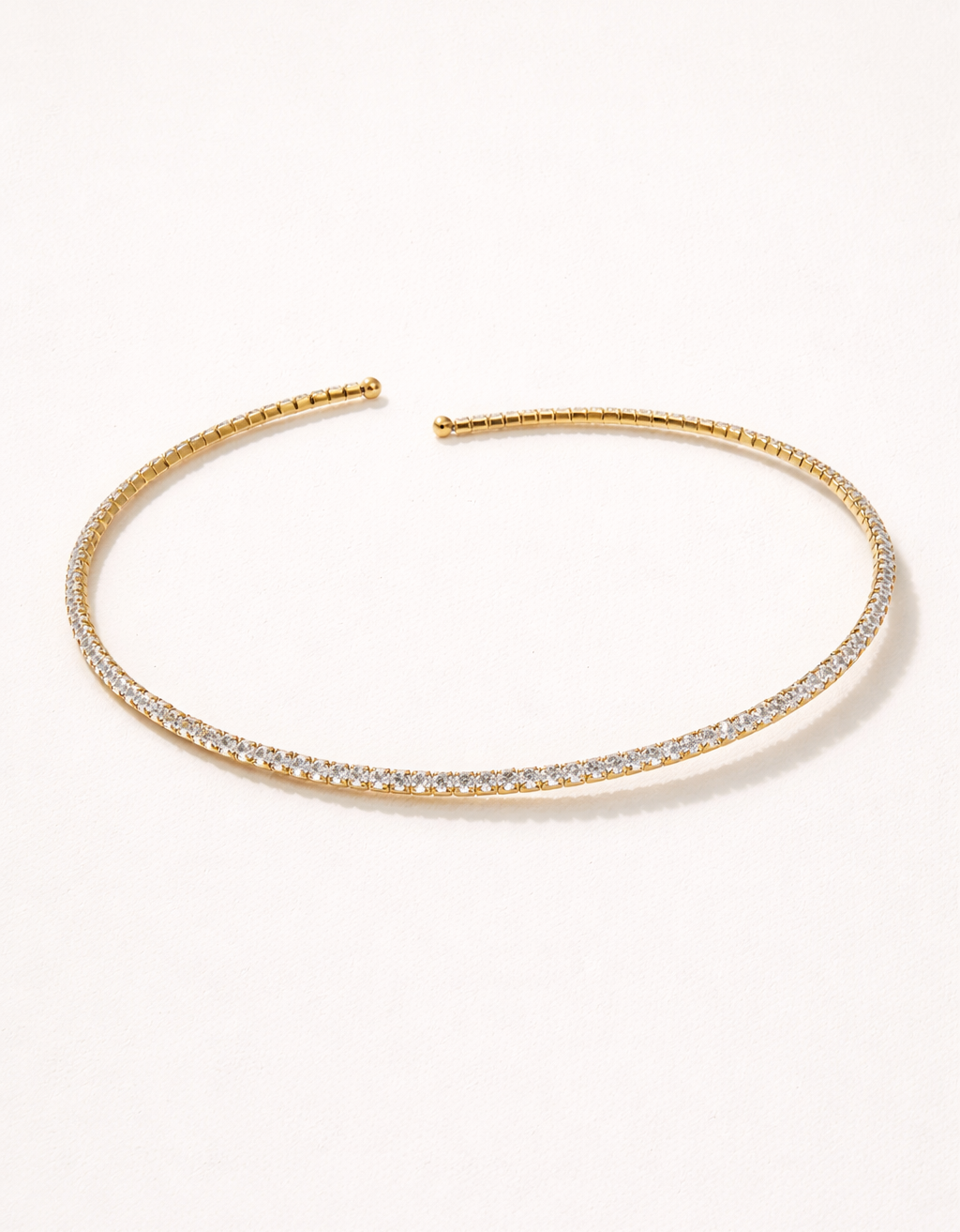 Gold headband with embedded crystals on a white background