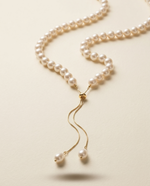Pearl necklace with a gold clasp on a beige background