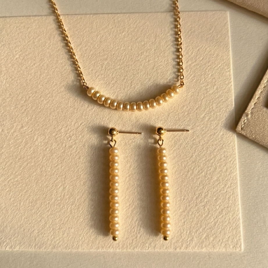 Gold necklace and earrings on a beige card