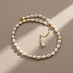 Pearl necklace with gold chain on a beige background