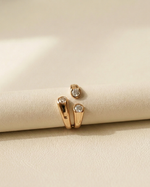 Gold ring with diamonds on a beige surface