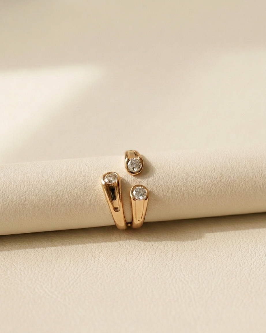 Gold ring with diamonds on a beige surface