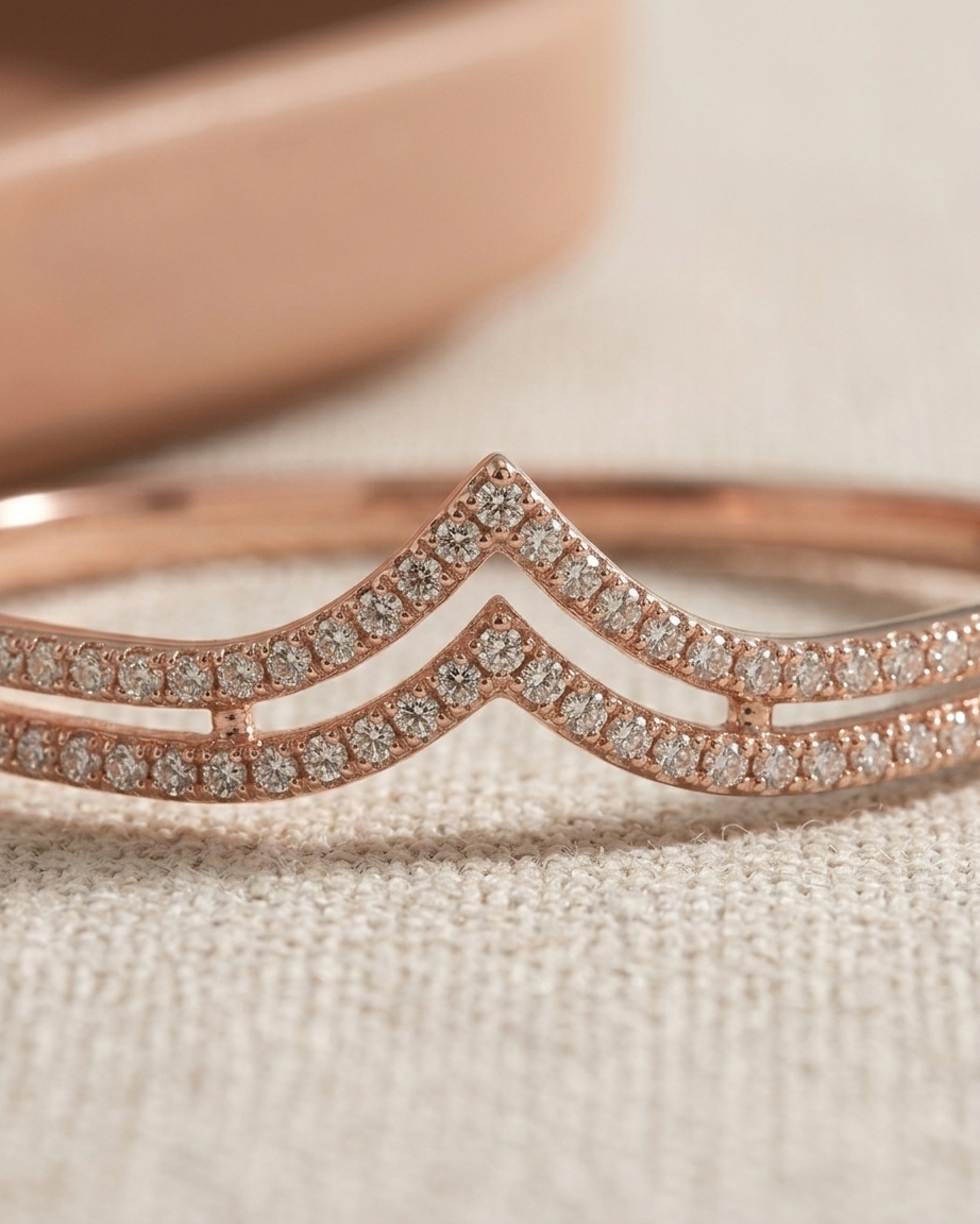 Rose gold bracelet with diamond accents on a soft beige background