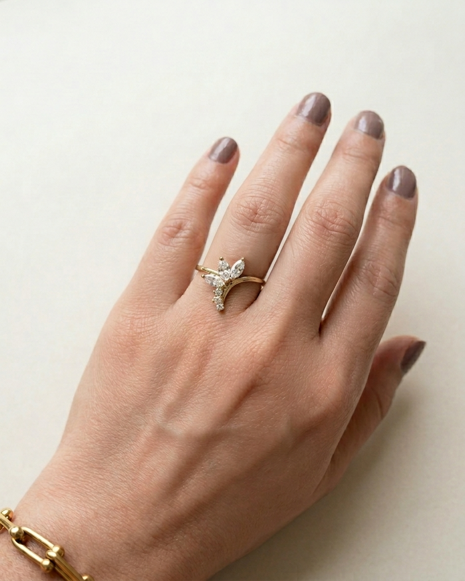 Hand wearing a gold ring with a diamond on a light background