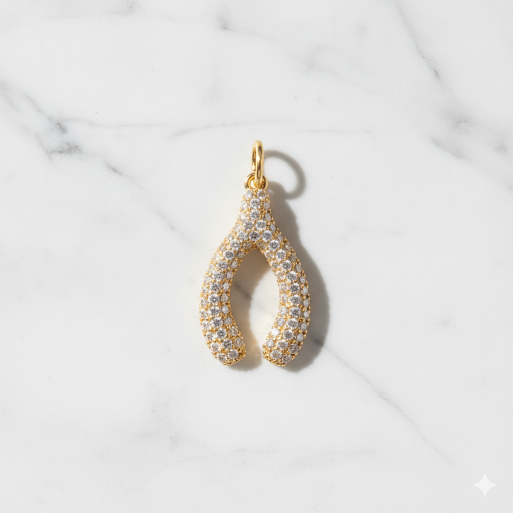 Gold and diamond teardrop pendant on a marble background