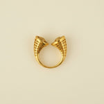 Gold ring with unique design on a light gray surface