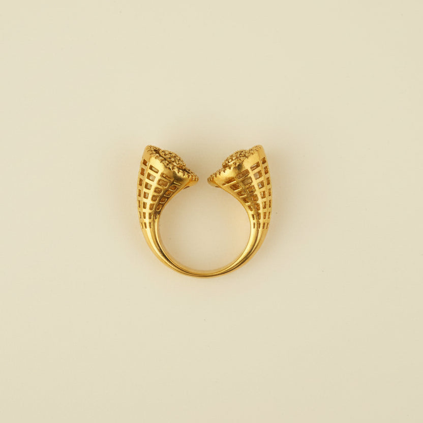 Gold ring with unique design on a light gray surface
