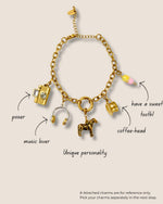 Gold charm bracelet with various charms on a beige background