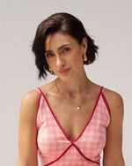 Woman wearing a golden necklace with a pearl ball 