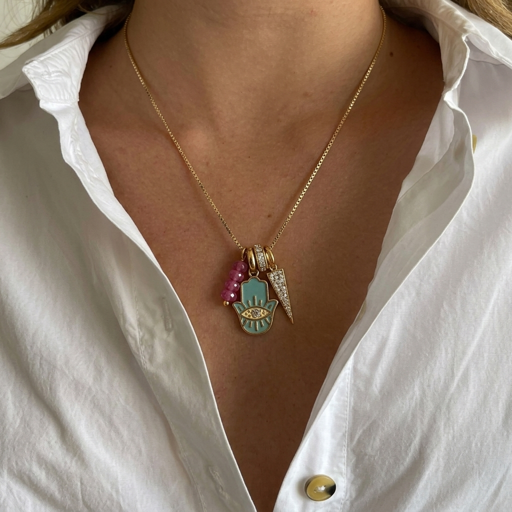 Necklace with charms worn by a person in a white shirt