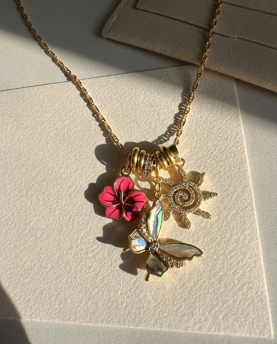 Necklace with floral and butterfly charms on a textured surface