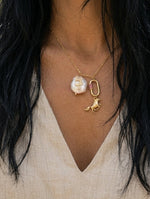Necklace with a pendant worn by a person with long black hair.