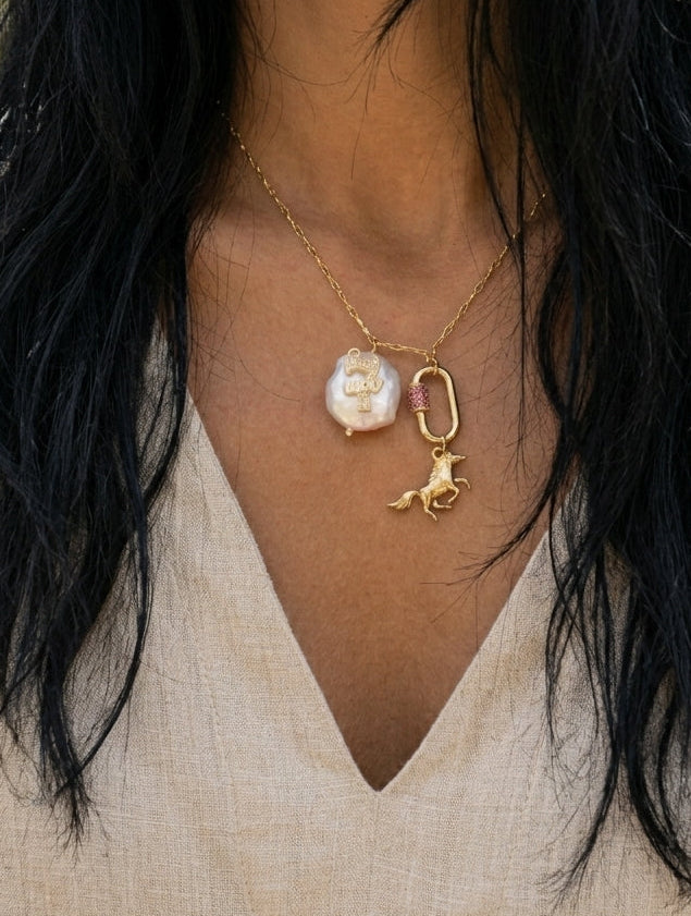 Necklace with a pendant worn by a person with long black hair.