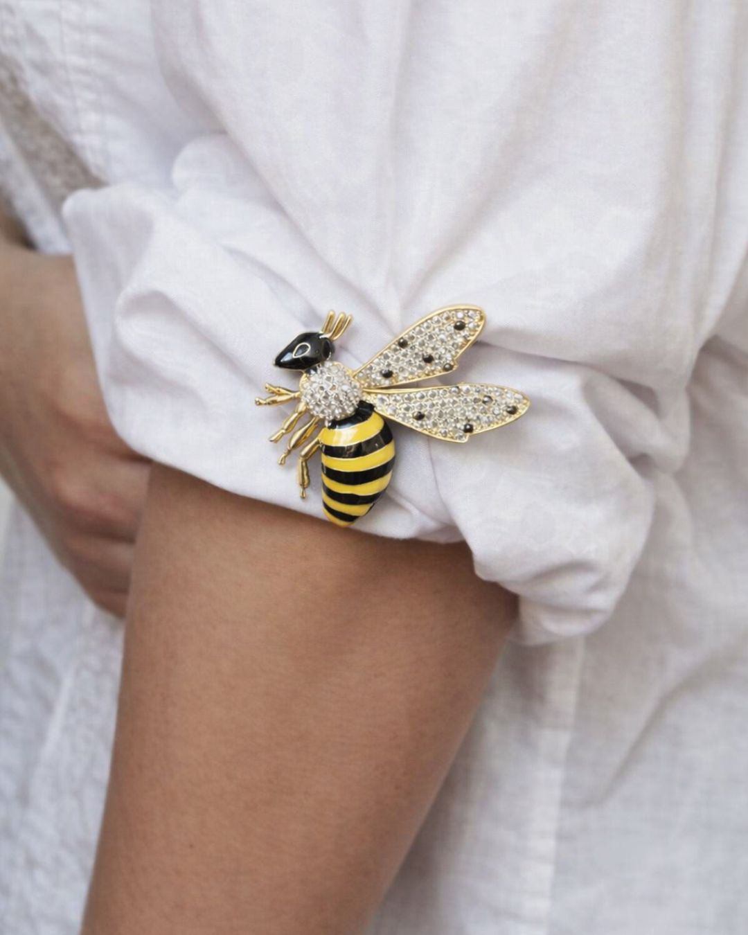 Bee-shaped brooch on a white shirt