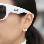 Close-up of an ear wearing gold earrings with a blurred background