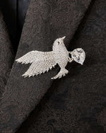 Diamanté bird brooch on a black textured fabric background