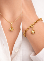 Gold necklace and bracelet set on a white shirt background