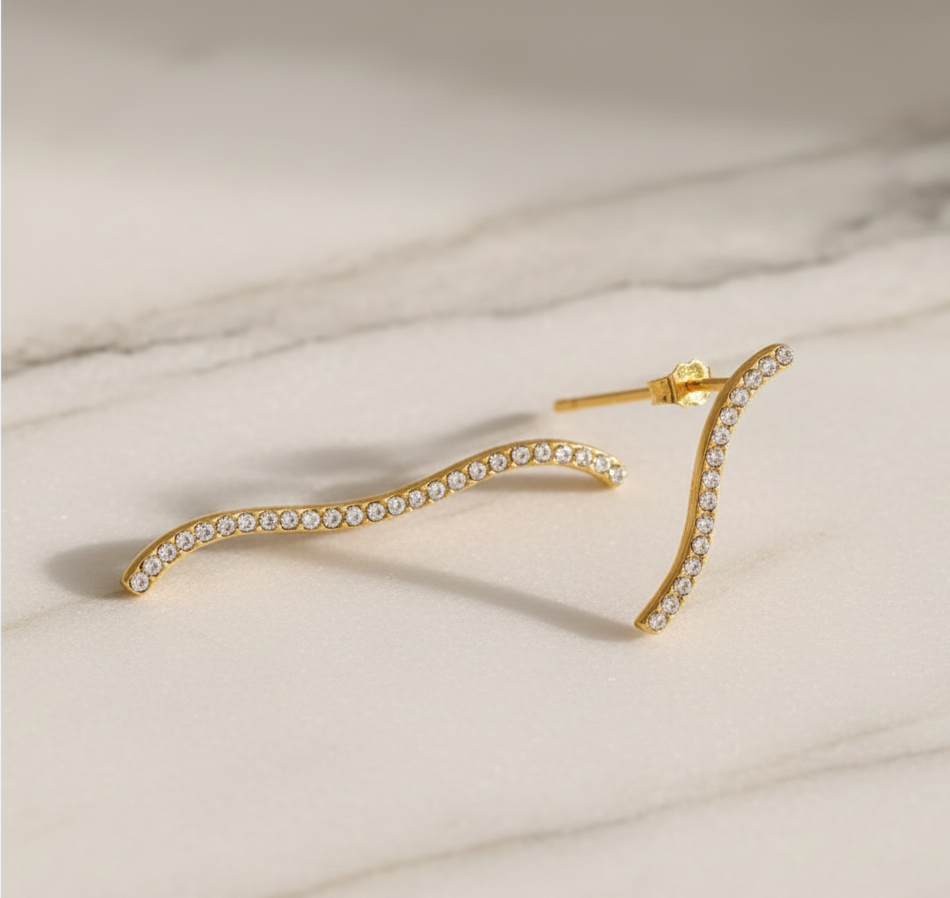 Gold hair clip with crystals on a beige marble background