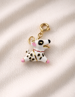 Dog-shaped keychain charm on a beige fabric background