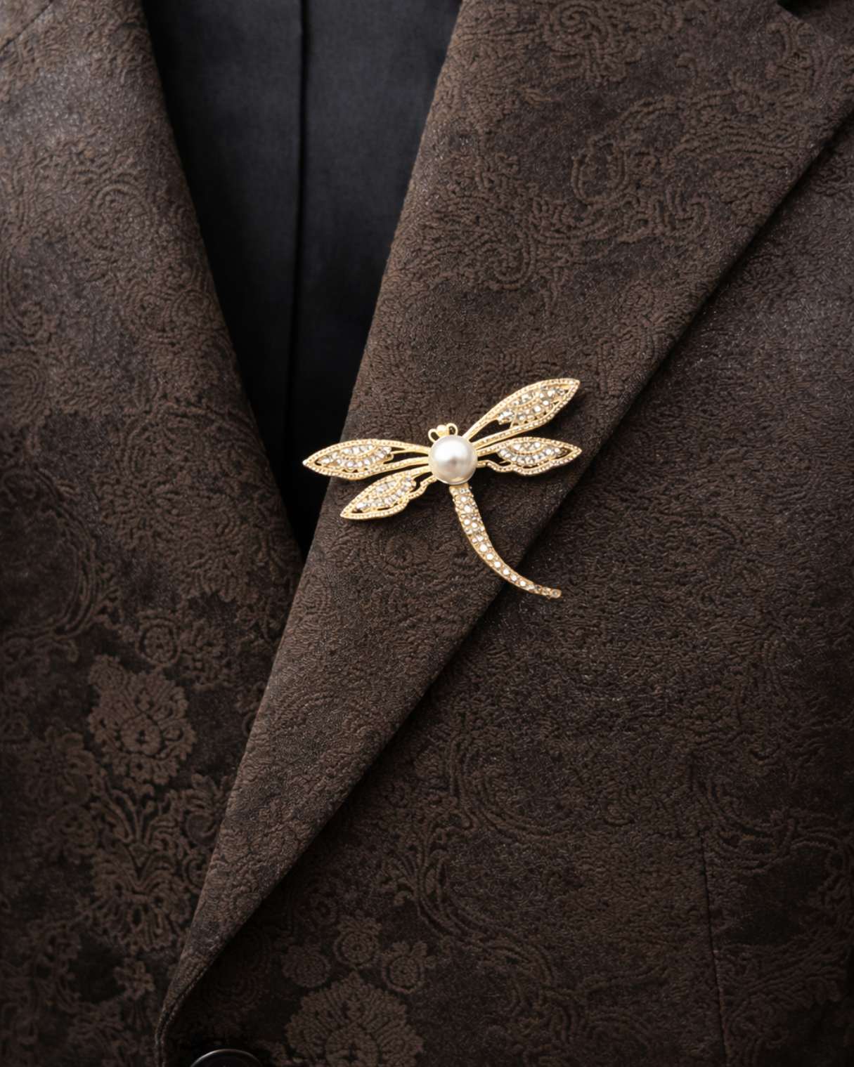 Gold dragonfly brooch on a brown textured fabric