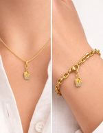 Gold necklace and bracelet with a small french fries pendant on a white shirt background