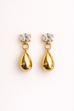 Gold teardrop earrings with clear gemstones on a white background