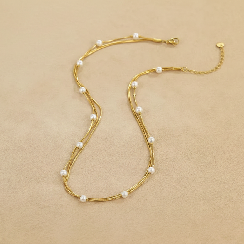 Gold necklace with pearls on a beige fabric background