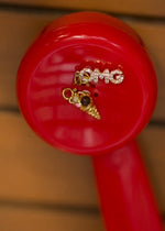 Red object with gold charms on a wooden surface