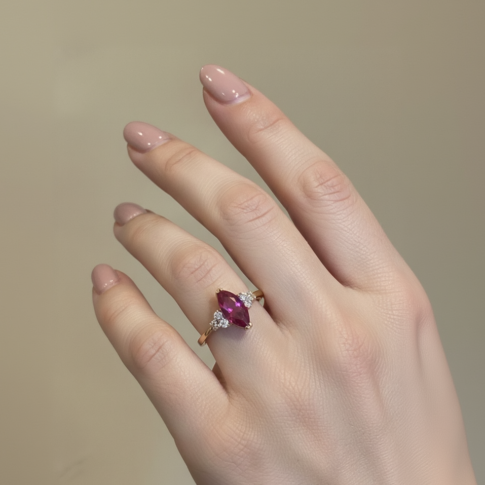 Hand wearing a ring with a marquise-shaped gemstone on a neutral background