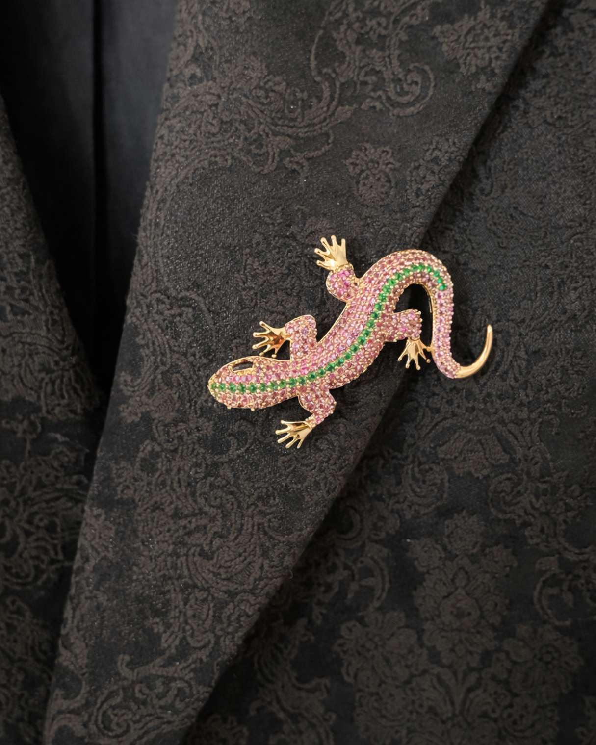 Jeweled lizard brooch on a black patterned fabric background