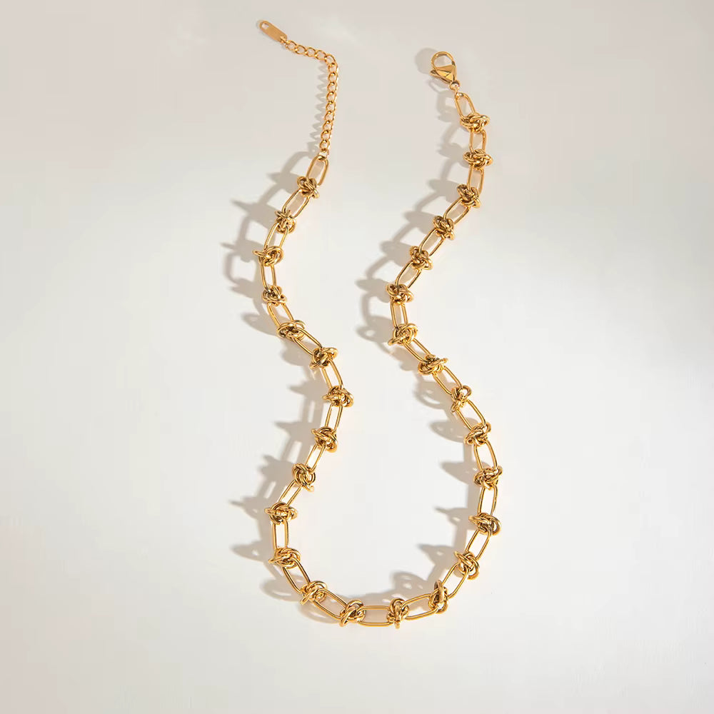 Gold chain necklace on a light gray background