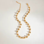 Gold chain necklace on a light gray background