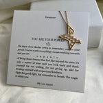 Gold necklace with star design on a card with motivational text