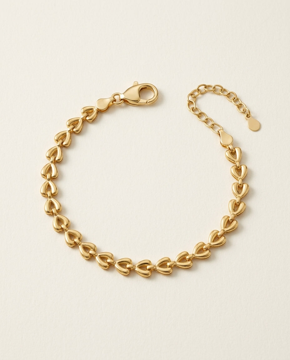Gold heart-shaped bracelet on a beige background